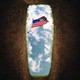 An American flag is viewed against the sky, from inside a freshly dug grave