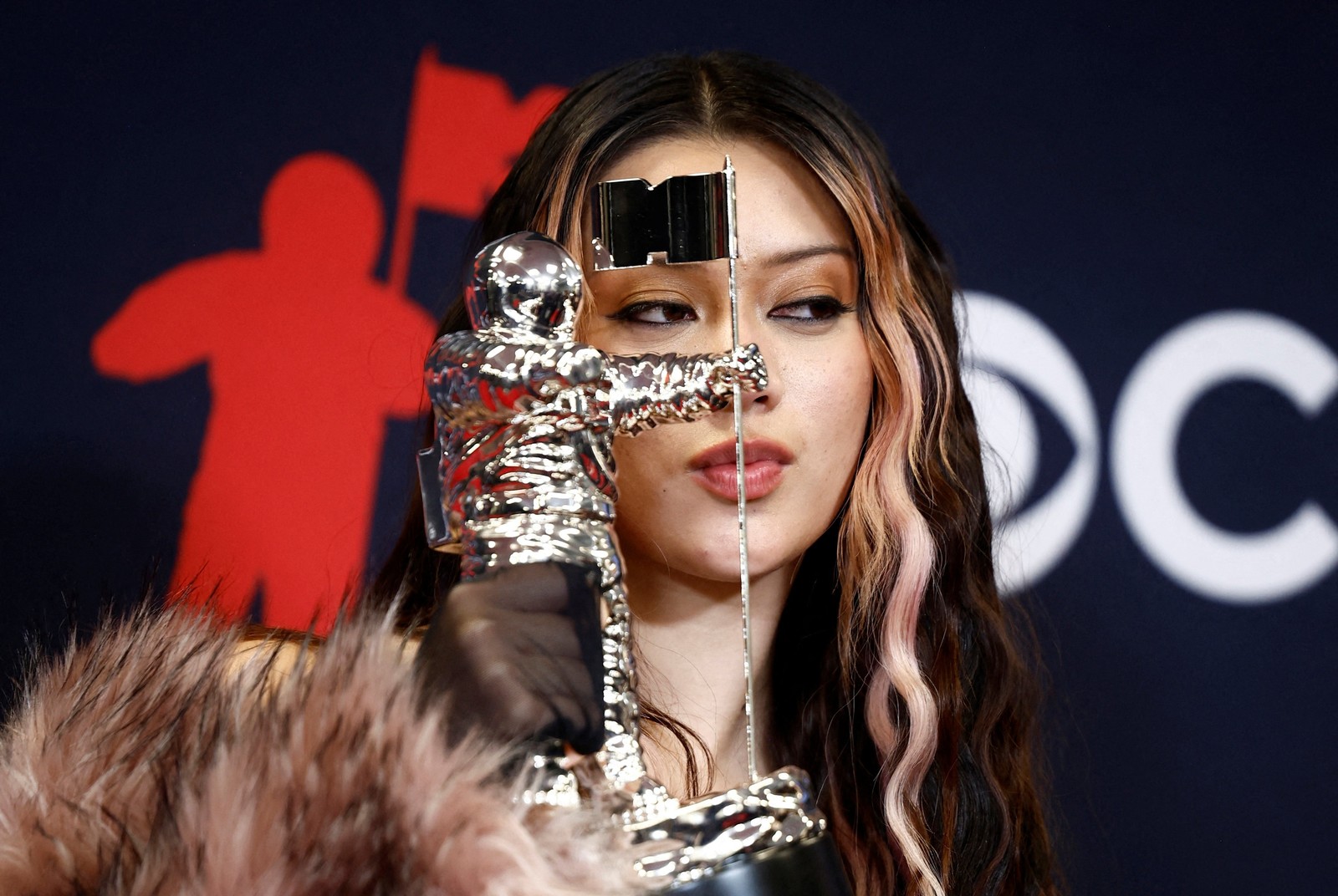 A performer holds up an astronaut-shaped award.