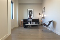 The author sits on a couch at his laptop in a Breather room.
