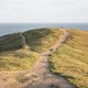 A single figure walking on a hilltop