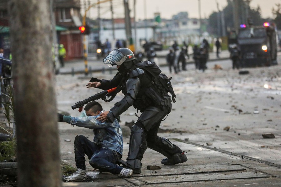 A security-forces member grabs a protester in the street.