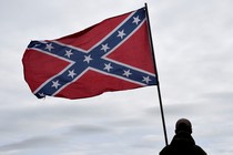 A Confederate flag waves in the wind.