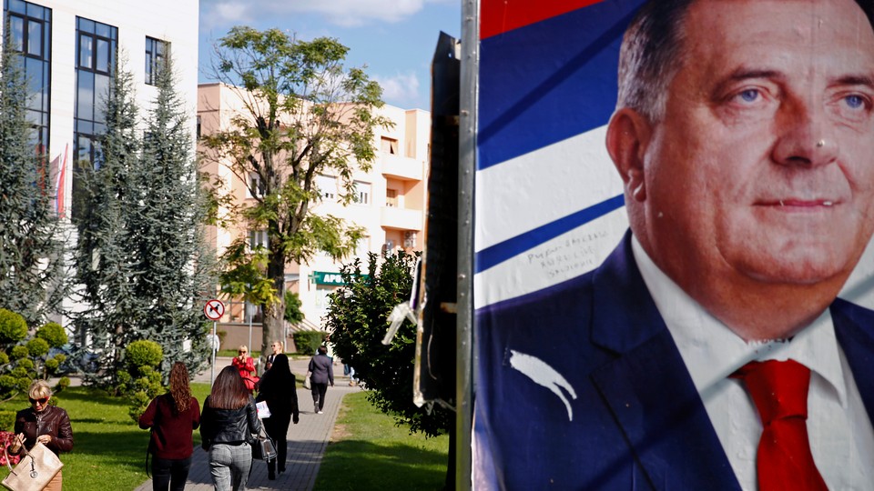 People walk by a Dodik campaign billboard in Banja Luka in September.
