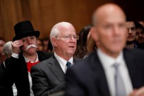 A monocle-wearing spectator looks on as Richard Smith, the former chairman and CEO of Equifax, testifies before the U.S. Senate Banking Committee.