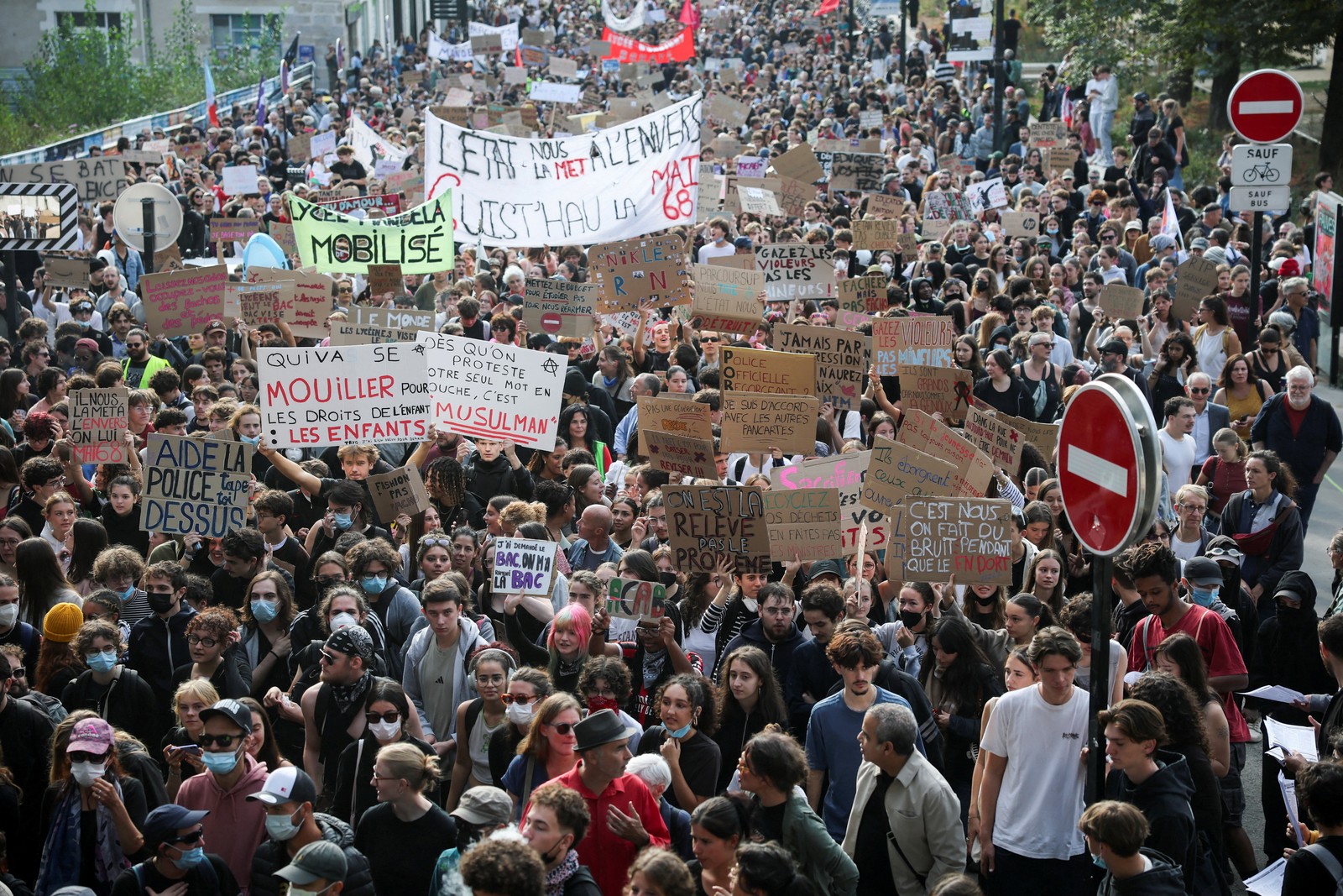 A large crowd of protesting students carrying many hand-made signs