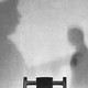 Photo of a wall with the shadows of two men in an execution room