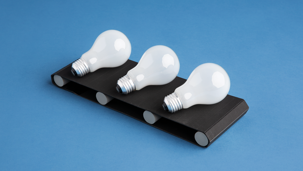 3 light bulbs on black conveyor belt on blue background