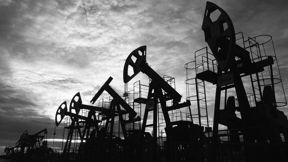 Oil derricks in the in the Republic of Bashkortostan, Russia, against a cloudy sky