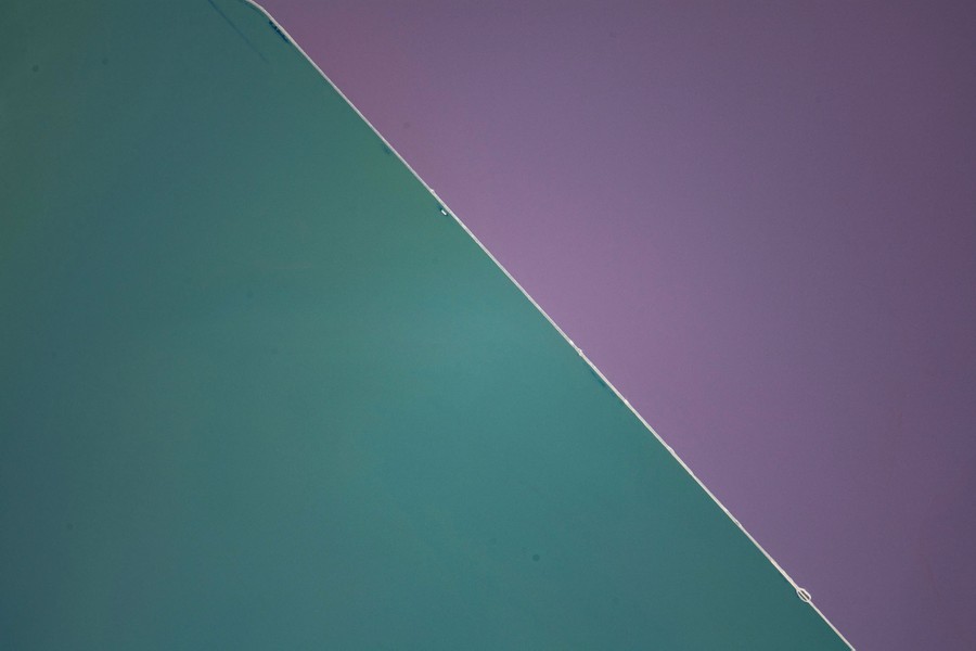 A broad stretch of a lake is seen, with a thin white line running diagonally through the center. Each side of the lake is a different color.