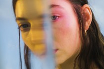 a color photograph portrait of Lorde seen through a reflective surface