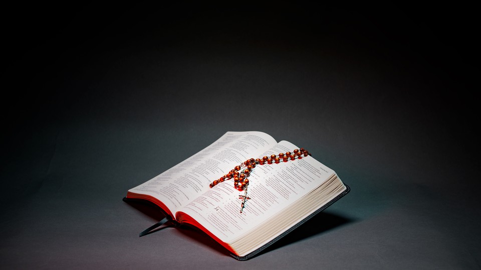 A photo illustration of a Bible with a rosary