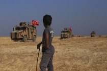 Turkish armored vehicles conduct a joint ground patrol with American forces in the "safe zone" on the Syrian side of the border with Turkey