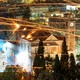 Streaks of sparks left by handmade rockets criss-cross over buildings in an old village center in Greece.