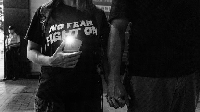 A protester shines a smartphone light near Victoria Park, the traditional venue of Hong Kong's Tiananmen candlelight vigil.