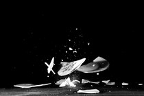 a white plate shatters on a black background