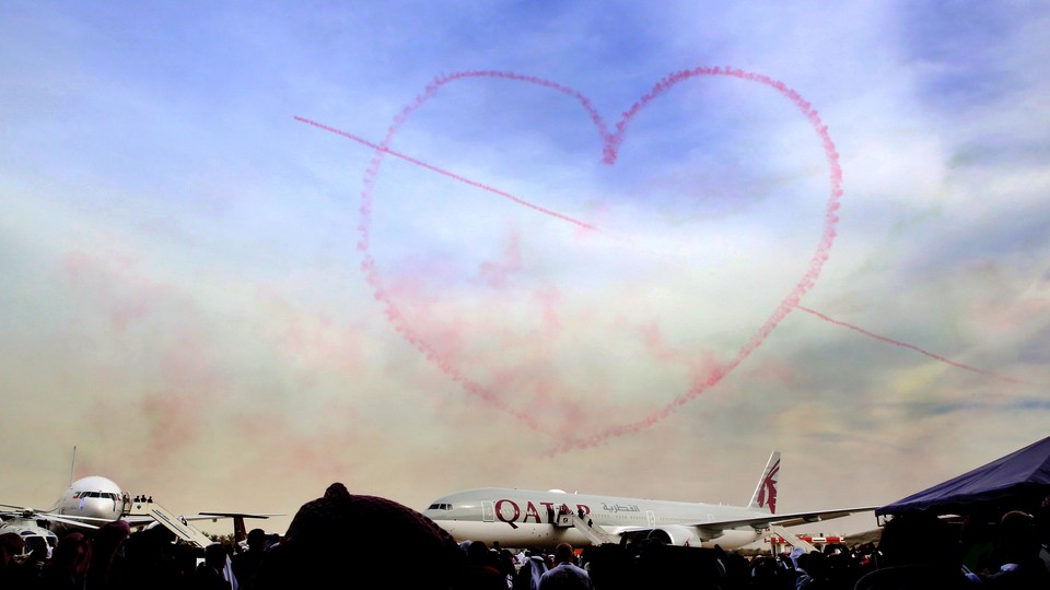 Pink smoke in the shape of a heart above an airplane