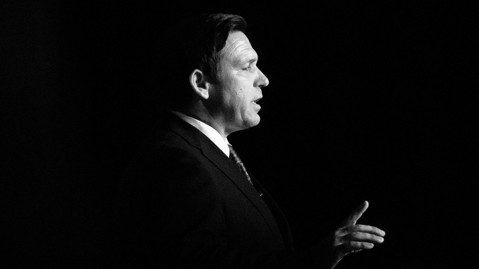 Black-and-white photo of Ron DeSantis in profile, talking and gesticulating
