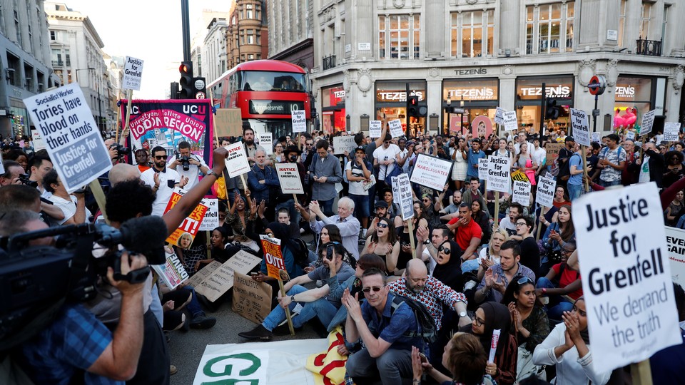 Demonstrators sit in the road during a protest in London's West End on June 16, 2017.
