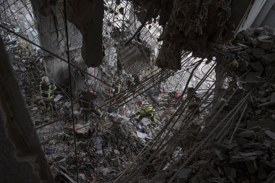 Rescuers work inside a bomb-damaged apartment building.