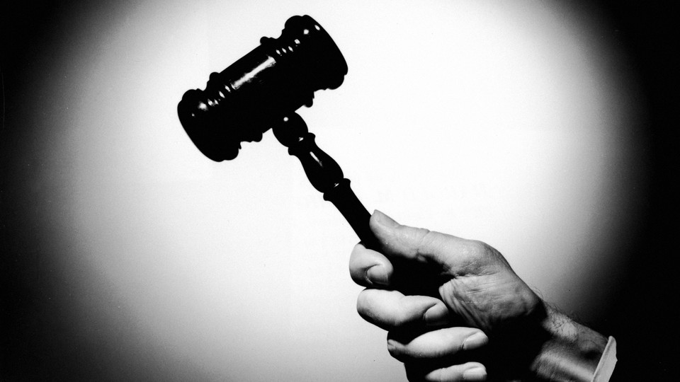 A hand holding a gavel