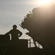 An image of a German soldier standing on top of a truck while he and others unload a US made Patriot missile.