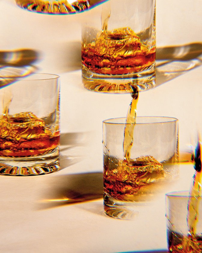 Pouring brown liquor in a glass