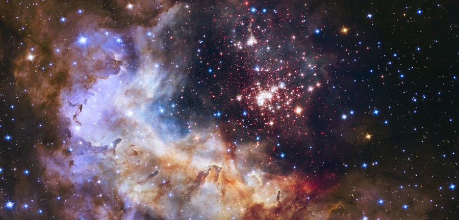 A bright cluster of stars is seen beside a large glowing cloud of gas and dust.