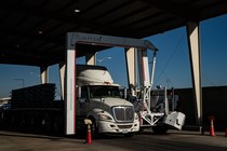 A news photo of a tractor trailer crossing the U.S. border with Mexico.