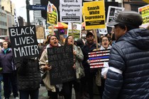 Black Lives Matter activists hold signs reading, "Black lives matter," "smash white supremacy," and "brown and indigenous people will resist."