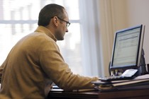 A man checks his email on his desktop computer.