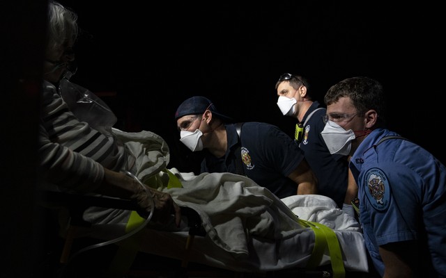 Paramedics prepare to transport a coronavirus patient to the hospital.