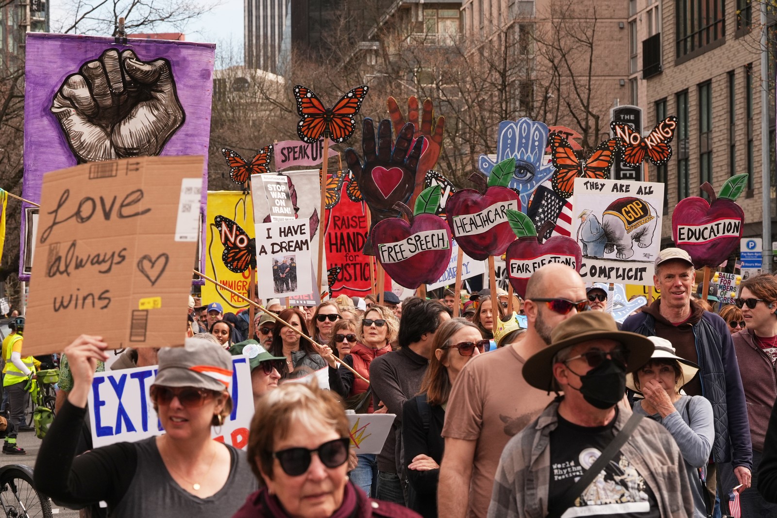 Protesters march in a Seattle Street, carrying signs that read 