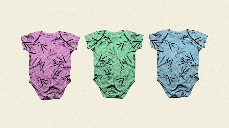 A row of baby onesies: one pink, one green, and one blue, each covered in a similar bamboo print.