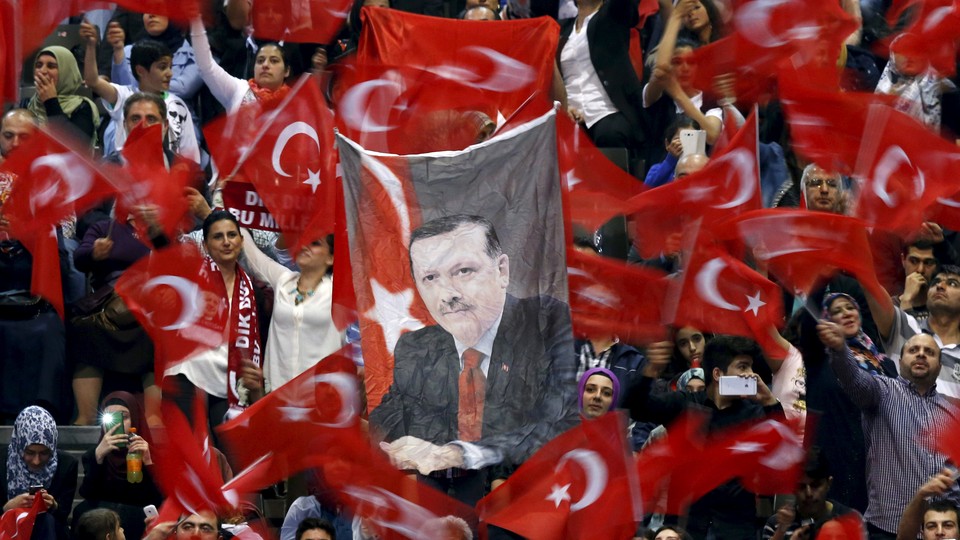 A portrait of Turkey's President Tayyip Erdogan is seen as supporters wave flags before his speech at the Ethias Arena in Hasselt, Belgium, May 10, 2015.