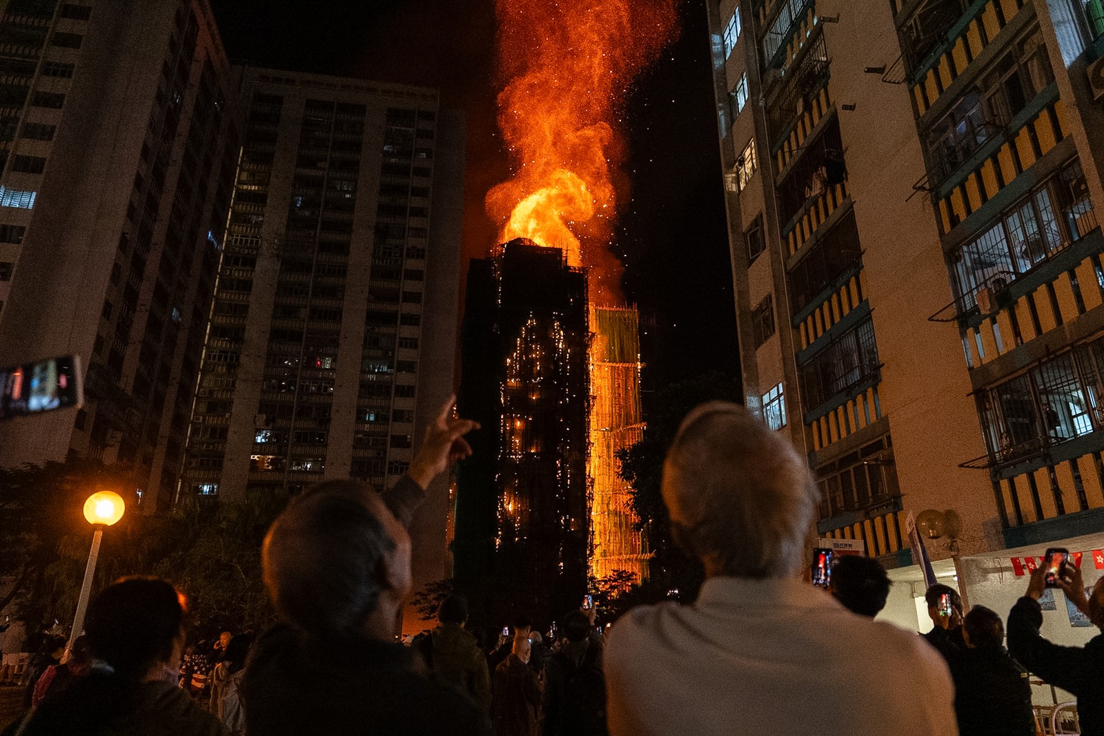 People look at flames engulfing a building complex in Hong Kong.