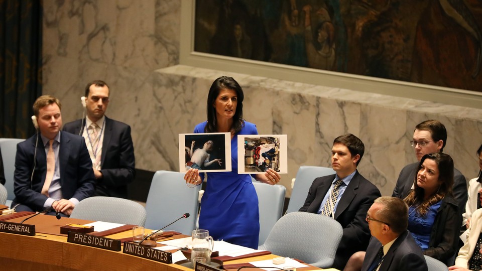 U.S. Ambassador to the United Nations Nikki Haley holds photographs of victims during a meeting at the United Nations Security Council on Syria at the United Nations headquarters on April 5, 2017.