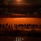 Migrants gathered at night in front of the border wall