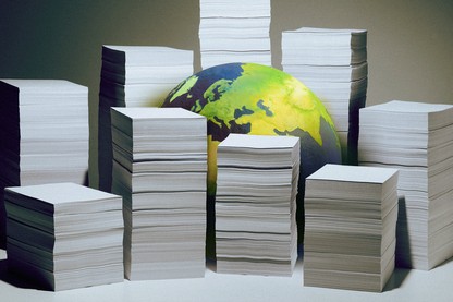 A globe sitting on a surface, partially obscured by stacks of white paper
