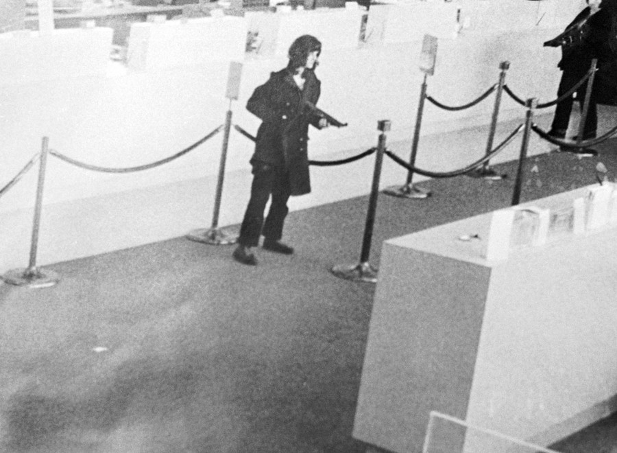 An image from a security camera in a bank, showing two people holding weapons during a robbery.