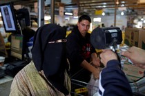 A Syrian refugee has her eyes scanned by a device to verify her identity so that she can receive her foodstuff at a refugee camp, in Mafraq, Jordan. 