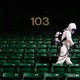 A worker disinfecting seats at a sports stadium