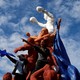 Protestors hold Nicaraguan flags standing on a statue