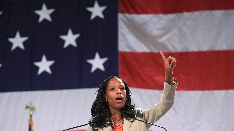 Mia Love stands in front of an American flag.