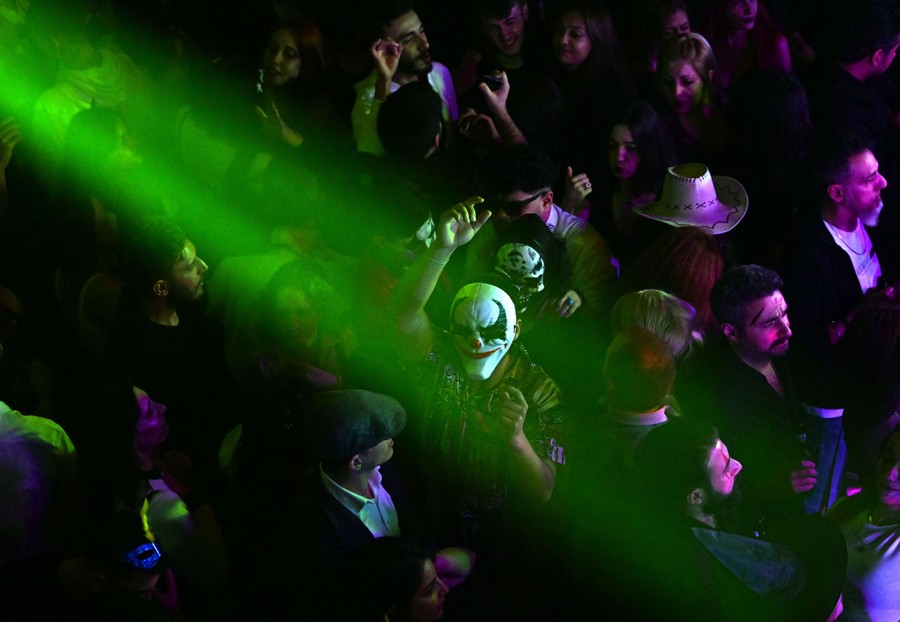 People, both costumed and not costumed, gather in a crowd for a festive event.