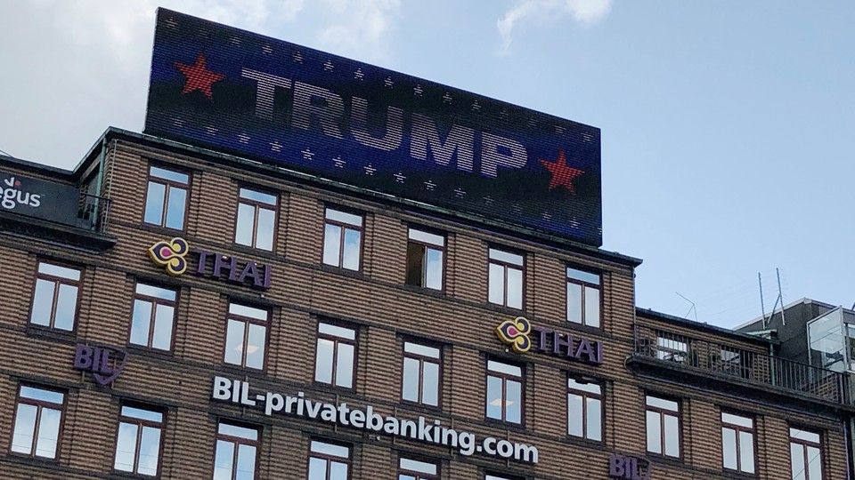 A digital billboard displays a sign reading "TRUMP" in Copenhagen.