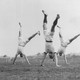 A black-and-white image of athletes doing cartwheels together