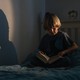 child reading a book alone in their bedroom