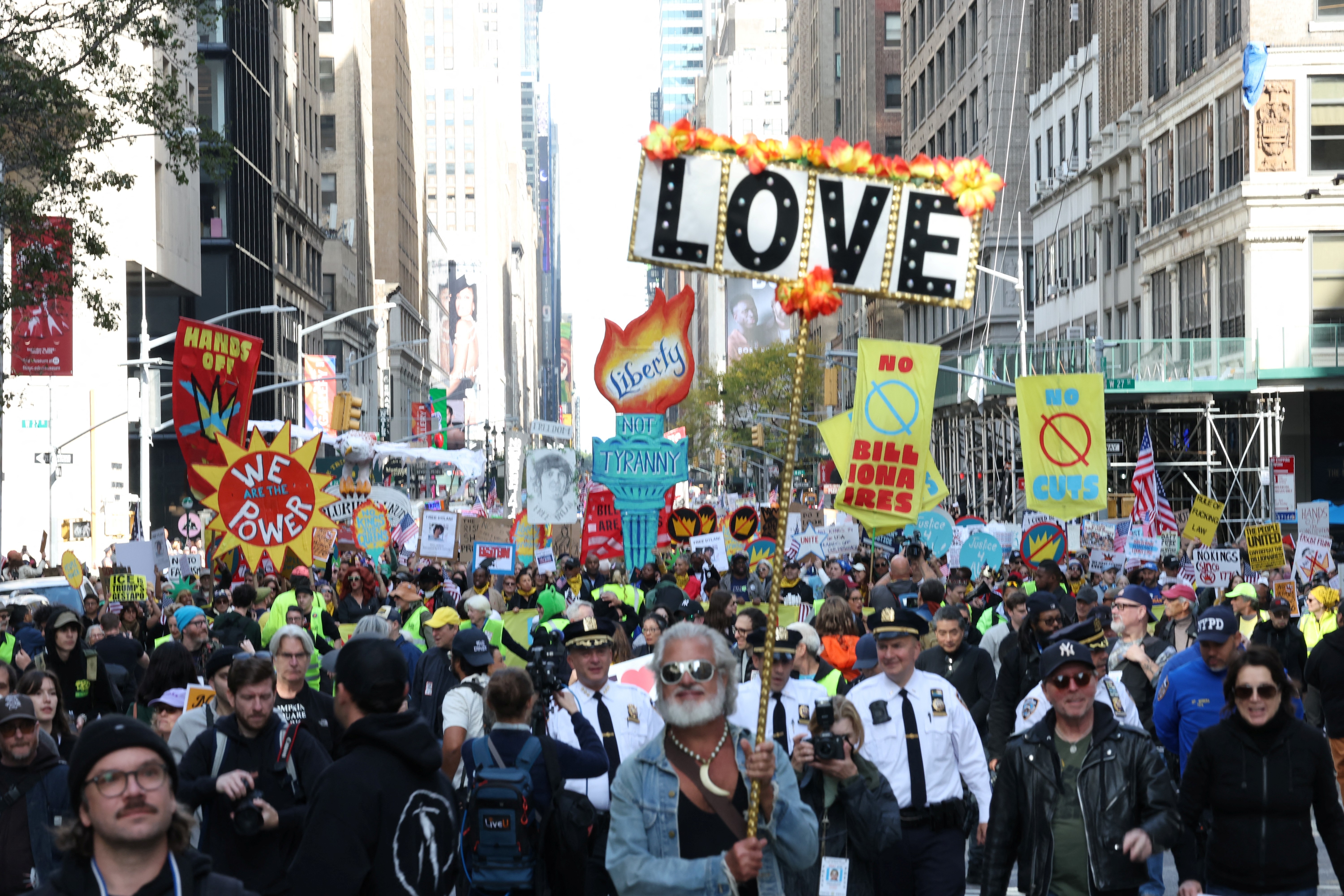 Protesters carry signs down a New York City street, including one that reads simply