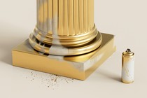 The base of a column spray-painted in gold; some of the white marble beneath is showing.