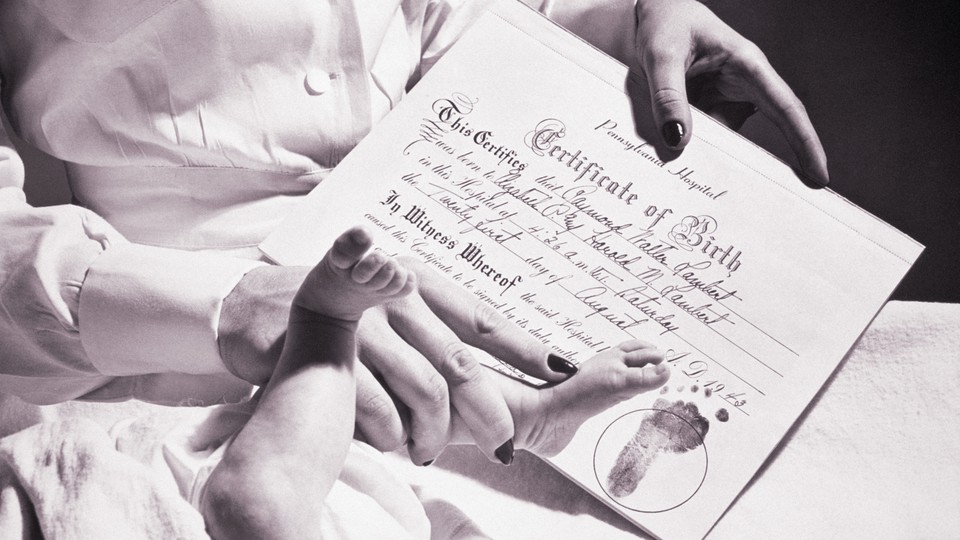 A photograph of a baby's foot being stamped on a birth certificate